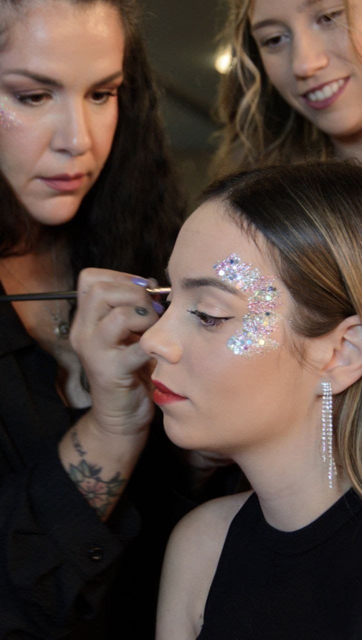 Maquilladora aplicando glitter a una invitada